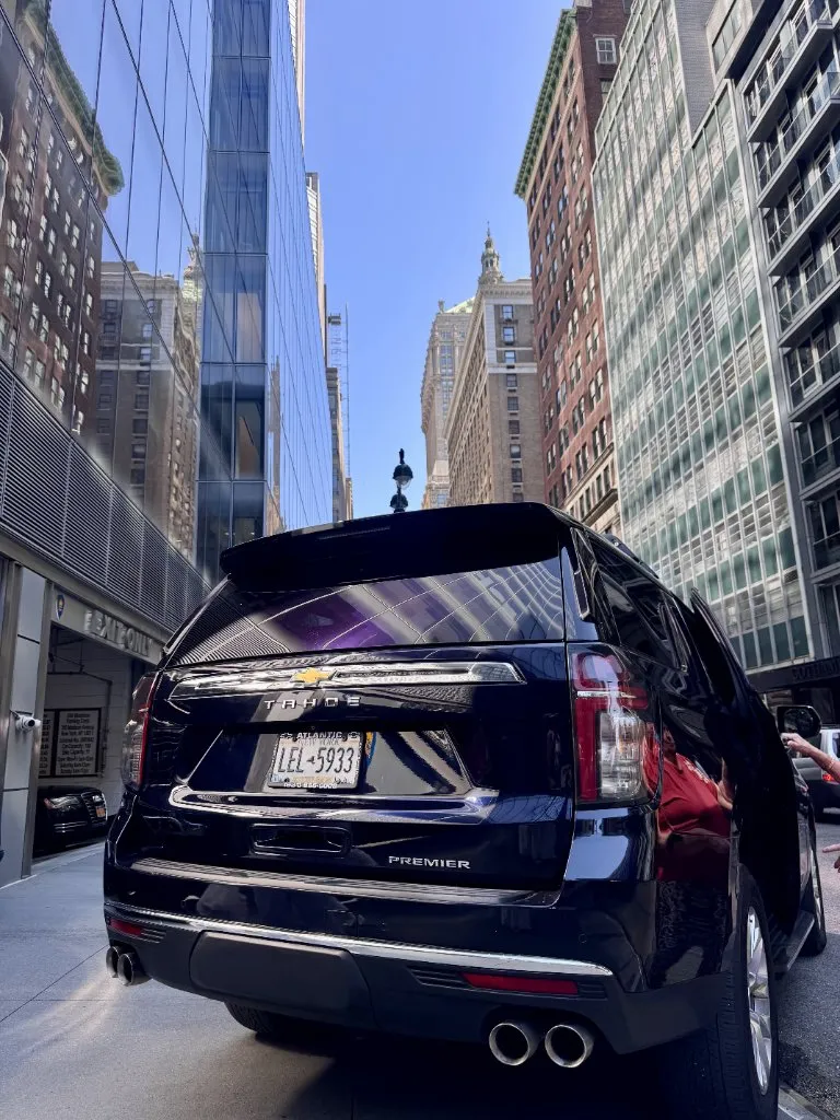 Luxury chauffeur vehicle interior with panoramic sunroof overlooking a Hamptons beach